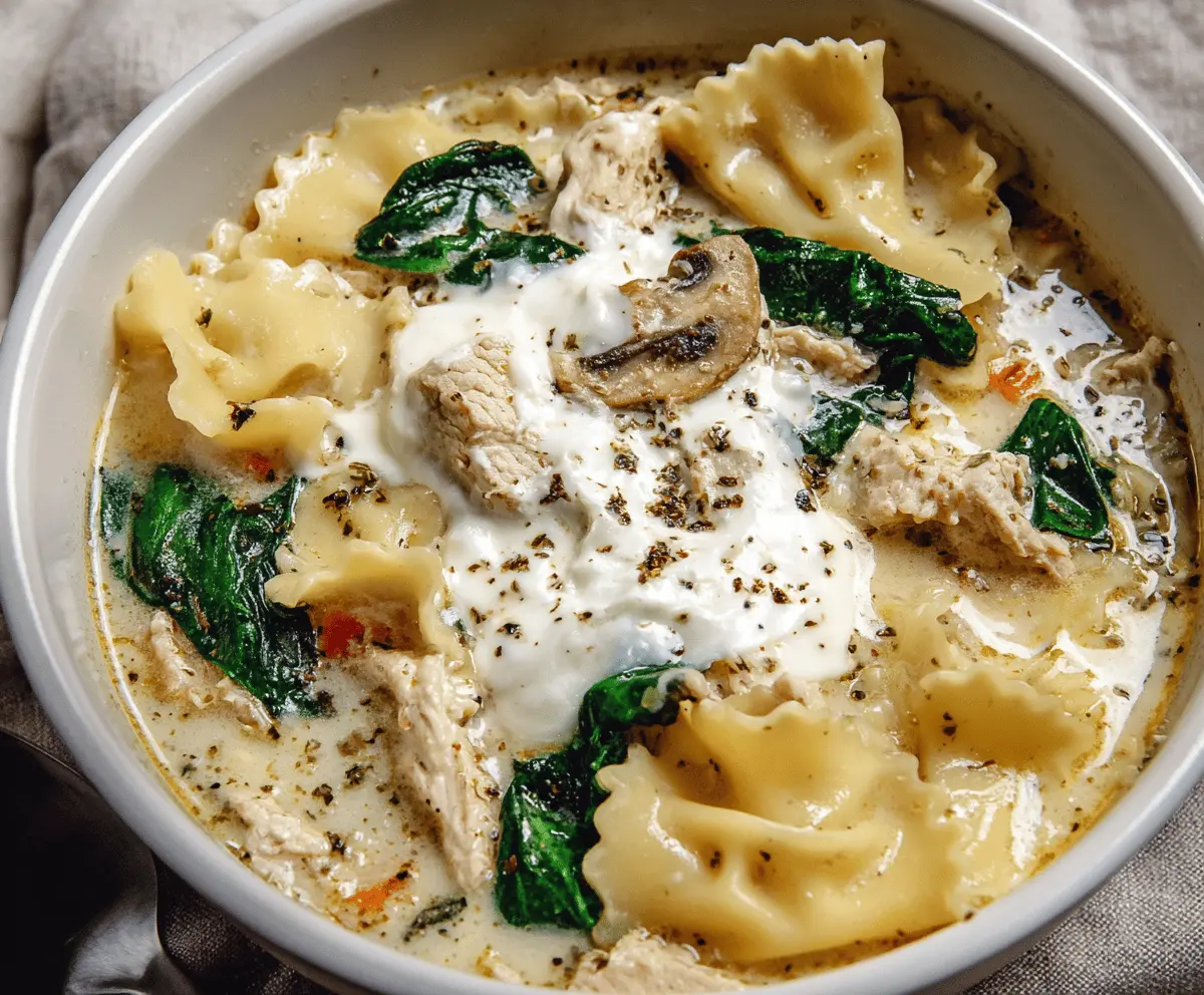 Creamy white lasagna soup with cheese, spinach, and basil in a bowl, garnished with herbs and served hot