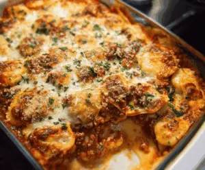 Delicious Million Dollar Ravioli Casserole topped with melted cheese and fresh herbs in a baking dish