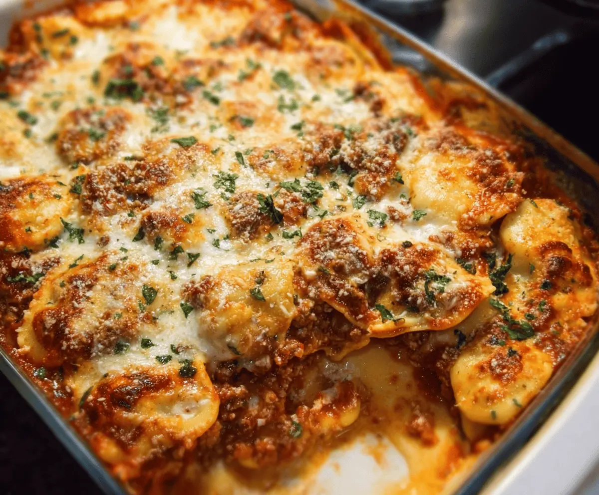 Delicious Million Dollar Ravioli Casserole topped with melted cheese and fresh herbs in a baking dish