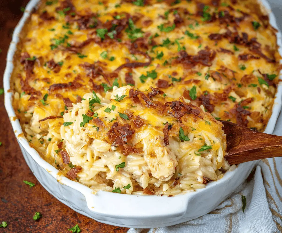 Creamy French Onion Chicken Orzo Casserole topped with melted cheese and caramelized onions, served in a baking dish.