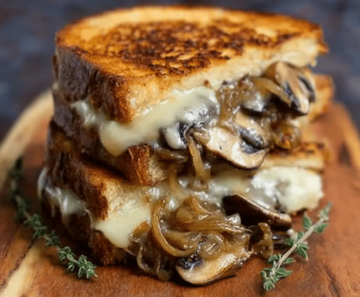 Delicious grilled cheese sandwich with melted gouda, roasted mushrooms, and caramelized onions on golden bread